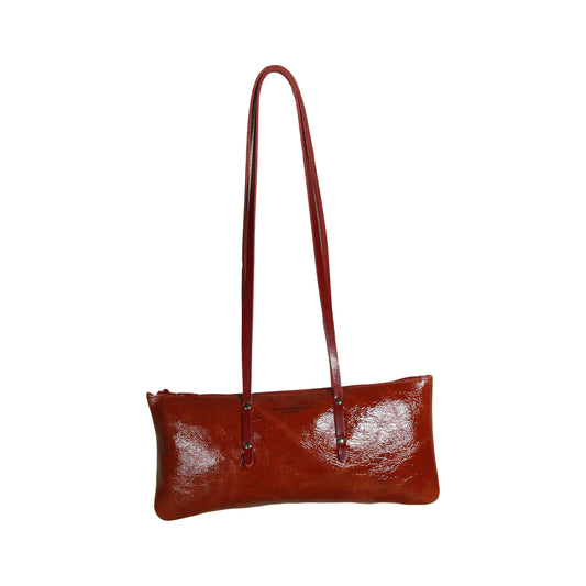 Sac Le Baguette en vachette velours brillant rouge, avec ses anses rouges fixées sur la face du sac, vu de face sur fond blanc.
