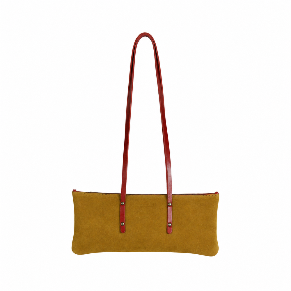 Sac Le Baguette en vachette velours ocre, avec ses anses rouges fixées sur la face du sac, vu de face sur fond blanc.